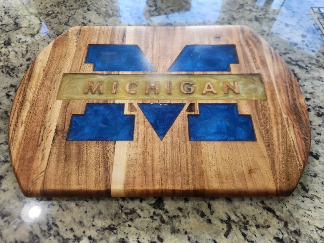 Wood cutting board with a block M inlay in blue and gold
